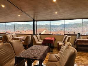 a restaurant with chairs and tables and a view of mountains at Cusco - Perú "Hotel Boutique Qorikallpa" The true essence of inka culture in Cusco
