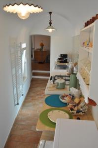 cocina con mesa y platos en el suelo en Roseus La Casa Vacanze nei Sassi, en Matera