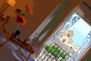 un jarrón con un girasol delante de una ventana en Roseus La Casa Vacanze nei Sassi, en Matera