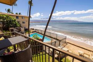 a balcony with a view of the beach and the ocean at Hono Kai Resort B7 in Wailuku