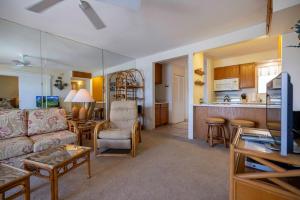 a living room with a couch and a kitchen at Hono Kai Resort B7 in Wailuku