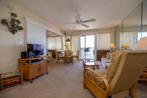 a living room with a couch and a tv at Hono Kai Resort B7 in Wailuku
