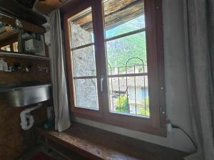 a window in a bathroom with a sink and a balcony at Garni Cà Stella in Bignasco
