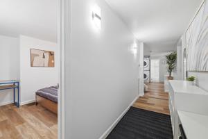 a hallway with a bed and a sink in a room at Pittsburgh Millvale A Bright & Cozy Private Bedroom with Shared Bathroom in Pittsburgh