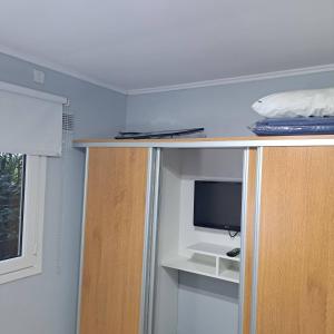 a room with a tv and a shelf with a tvictericter at Rincon de Gulliver in Pinamar