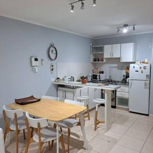 a kitchen with a wooden table and a white refrigerator at Rincon de Gulliver in Pinamar