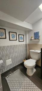 a bathroom with a toilet and two pictures on the wall at Aparta estudio campestre in Chía