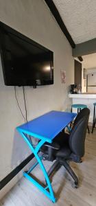 a blue table with a chair and a tv on a wall at Aparta estudio campestre in Chía