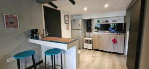 a kitchen with a counter and two blue stools at Aparta estudio campestre in Chía