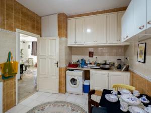 a kitchen with white cabinets and a washing machine at Meraki house in La Marsa
