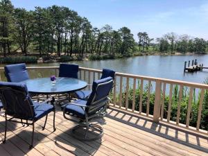 a table and chairs on a deck with a view of a river at Waterfront Round House View in Oakdale
