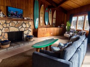 a living room with two couches and a fireplace and surfboards at Waterfront Round House View in Oakdale