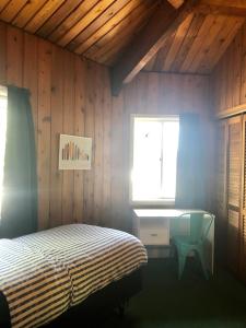 a bedroom with a bed and a desk and a window at Waterfront Round House View in Oakdale