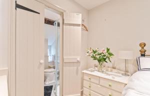 a bedroom with a bed and a dresser with a mirror at Cosy Llangattock Hideaway in Crickhowell +30 photos