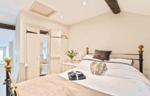 a bedroom with a bed with white sheets and a mirror at Cosy Llangattock Hideaway in Crickhowell