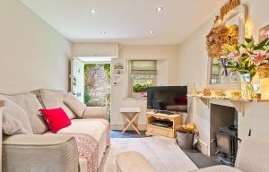 a living room with a couch and a tv at Cosy Llangattock Hideaway in Crickhowell