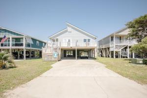 a house on the beach with a driveway at Changes In LAttitude by Oak Island Accommodations in Oak Island