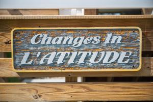 a sign that says changes inhalla on a wooden bench at Changes In LAttitude by Oak Island Accommodations in Oak Island