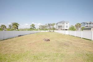 a large yard with a white fence at Changes In LAttitude by Oak Island Accommodations in Oak Island