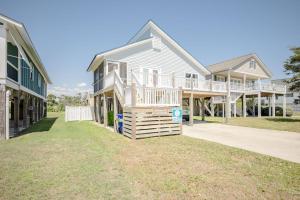 a house with a deck on the side of it at Changes In LAttitude by Oak Island Accommodations in Oak Island