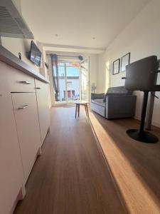 a room with a bed and a desk and a kitchen at Appartement 1 chambre vu sur jardin Appart A in La Roche-sur-Yon