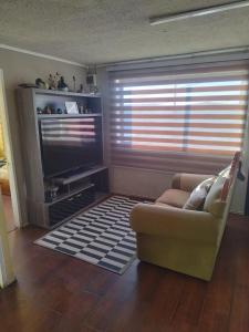 a living room with a couch and a flat screen tv at Hospedaje LARRAIN in Valparaíso