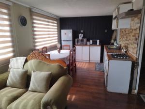 a kitchen and living room with a couch and a table at Hospedaje LARRAIN in Valparaíso