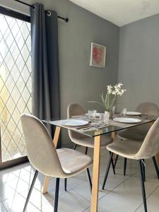 a dining room with a glass table and chairs at Casa Moderna, Ubicación Estrategjca in Cedro