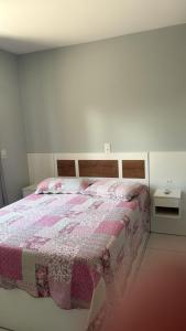 a white bedroom with a bed with a pink blanket at Apto lateral mar in Porto Belo