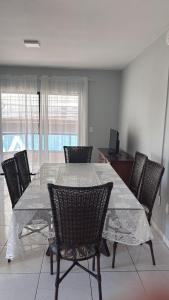 a dining room with a glass table and chairs at Apto lateral mar in Porto Belo +8 photos