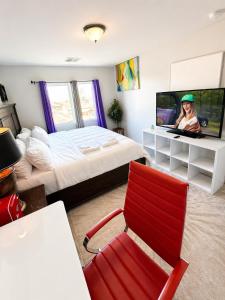 a bedroom with a bed and a red chair at Penn Signature Airport Short Term Rental PHX in Phoenix