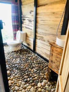 a bathroom with a toilet and a rocks floor at Sơn Tra Our House in Bản Bé +27 photos