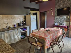 a kitchen with a table with chairs and a sink at Casa Manipa -3 dormitorios in Cafayate +5 photos