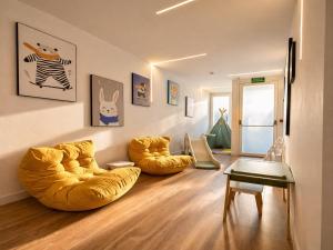 a living room with two yellow bean chairs and a table at Miriam by Dozzze in Madrid