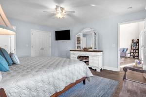 a bedroom with a bed with a ceiling fan and a mirror at Clear For Take Off by Oak Island Accommodations in Caswell Beach