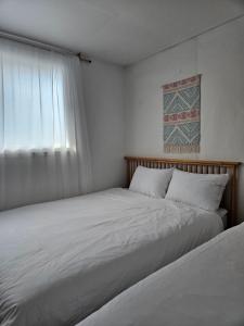two beds in a small room with a window at SNU Station 13min, Line 2, Hongdae,Gangnam 30min, 6pax in Seoul