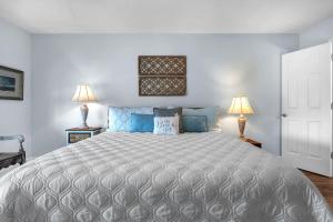 a bedroom with a large bed with two lamps at Clear For Take Off by Oak Island Accommodations in Caswell Beach