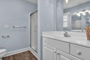 a white bathroom with a sink and a shower at Clear For Take Off by Oak Island Accommodations in Caswell Beach +56 photos