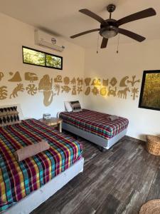 a bedroom with two beds and a ceiling fan at Alma Vita Punta Mango in Jucuarán