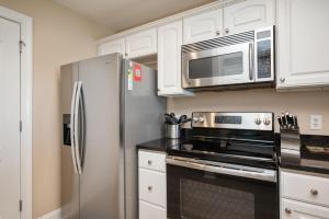a kitchen with a stainless steel refrigerator and microwave at Clearly Hooked by Oak Island Accommodations in Oak Island