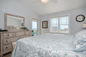 a bedroom with a bed and a dresser and a mirror at Clearly Hooked by Oak Island Accommodations in Oak Island