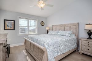 a bedroom with a bed and a ceiling fan at Clearly Hooked by Oak Island Accommodations in Oak Island +41 photos