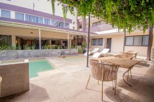 a patio with a table and chairs next to a building at Eco City Hoteles in Tuxtla Gutiérrez