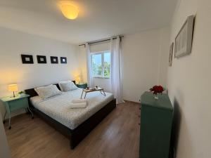 a small bedroom with a bed and a window at Suites Setúbal - River View in Setúbal