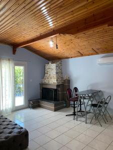 a living room with a table and a fireplace at Nadia's Beach House in Pefkari