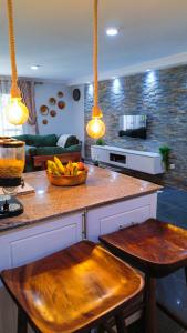 a kitchen with a counter with a bowl of fruit on it at The apartment Bwebajja 3 in Namulanda
