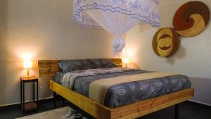a bedroom with a wooden bed and two lamps at The apartment Bwebajja 3 in Namulanda