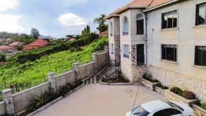 a white car parked in front of a house at The apartment Bwebajja 3 in Namulanda