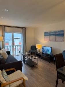 a living room with a couch and a tv at Suites Setúbal - River View in Setúbal