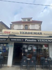 a restaurant with tables and chairs in front of a building at Pensión Restaurante Verdemar in Vigo